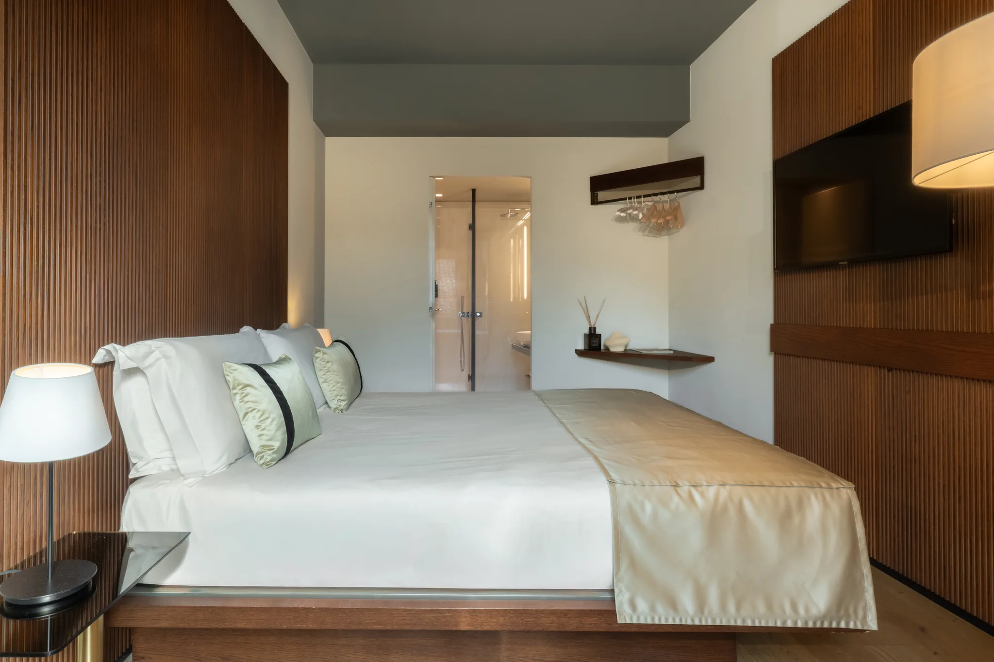 Suite — bedroom perspective, warm walnut and soft textiles